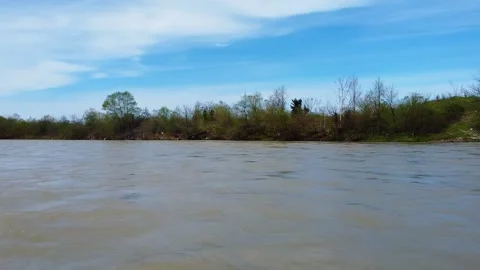 Fast muddy river drone pan left fromriverside Stock Footage 241220074