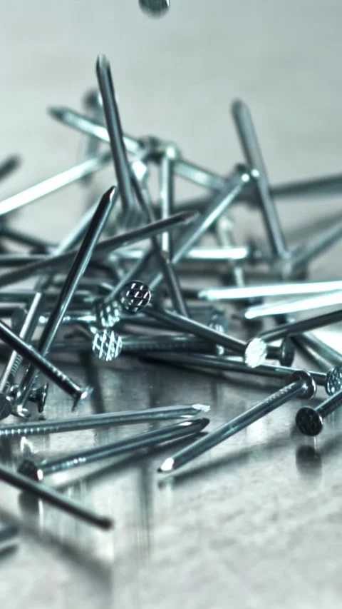 Fast nails collide with reflective metal surface vividly Filmed on a high-speed Stock Footage 335395261