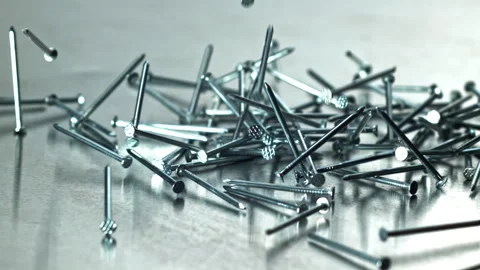 Fast nails collide with reflective metal surface vividly Filmed on a high-speed Stock Footage 335411424