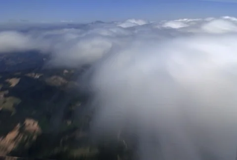 A fast-paced flight rushes over a thin layer of puffy clouds that still allows Video stock 86772530