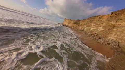 Fast-paced ocean surf rolls toward cliffside shores Stock Footage 344550848