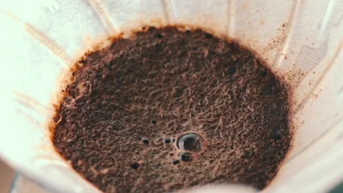 Fast-paced video of brewing ground coffee in a paper filter. Macro close-up Stock Footage 169801618