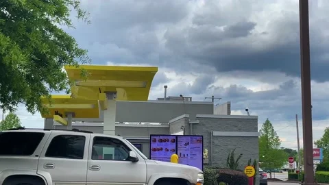 Fast pan of McDonalds back of drive thru on a busy day with storm clouds cars Stock Footage 152431969