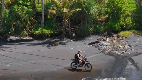Fast parallel drone tracking shot alongside a dirt bike rider speeding along Stock Footage 312719776
