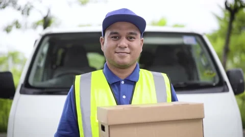 Fast post shipment service concept. Young asian deliveryman wear blue cap holdin Stock Footage 137437179