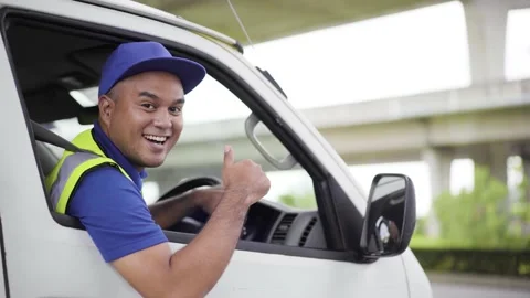 Fast post shipment service concept. Young asian deliveryman wear blue cap sittin Stock Footage 137437313