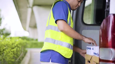 Fast post shipment service concept. Young asian deliveryman wear blue cap standi Stock Footage 137630316
