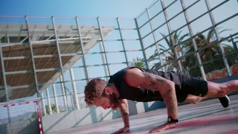 Fast push-ups of motivated guy in great body shape dressed in total black Stock Footage 117129842