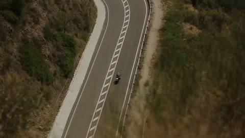 Fast riding of a motorcyclist on an empty road. Roadside of the city top view Stock Footage 163209029