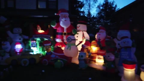 Fast Right To Left Pan Of Inflatable Christmas Decorations Santa Claus Elves Stock Footage 153761493