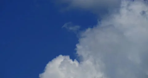 Fast roiling clouds enter bottom frame covering blue sky 100% Stock Footage 137542977