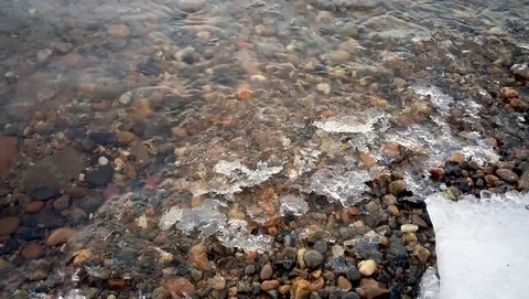 Fast shallow river forms the ice pieces on the shore Stock Footage 77690574