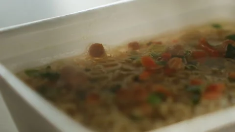 Fast soup dish. Easy hot noodle snack. Rapid served broth with noodles in tray Stockbeeldmateriaal 345520693