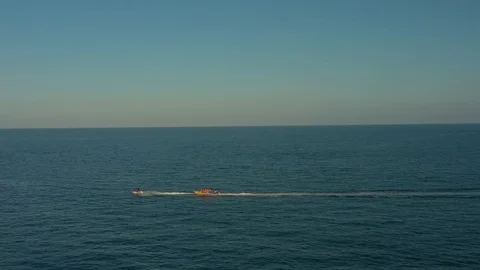 Fast speed boat floating on ocean water along horizon line in sunset moving air Stock Footage 124416175