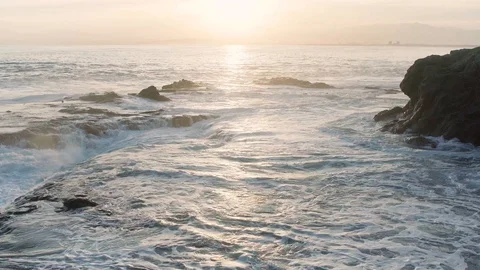 Fast Speed Breaking Foaming Wave to Reef Rock with Mountain Before Sunset Stock Footage 128946577
