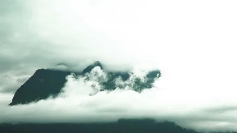 Fast speed overcast cloudy moving on sky and huge mountains hidden in cloudy Stock Footage 198799401