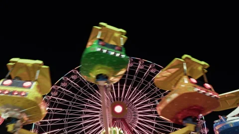 Fast Spinning Thrill Ride At Amusement Park At Night With Ferris Wheel Vídeo Stock 336419398