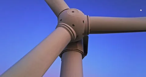 Fast Spinning Wind Generator Base From Low Angle Against Clear Blue Sky Backdrop Video stock 300486406