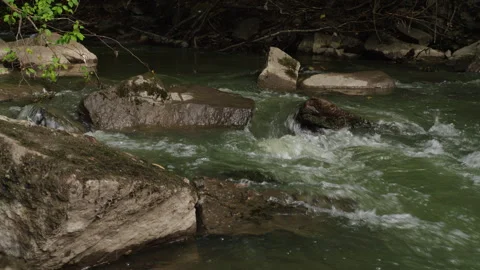 Fast Stream Water Breaking Around Large Rocks in Norway Video stock 345725707