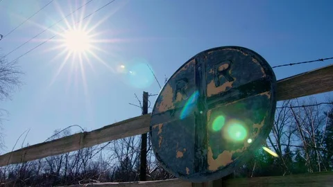 Fast Time lapse Of Rising Sun with Old Railroad Crossing Sign on Fence, 4k Stock Footage 125008564