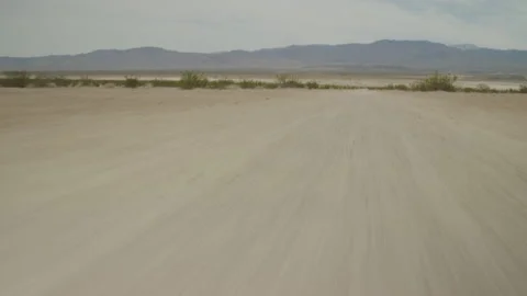 Fast tracking tilt up on road in dry lakebed in Johnson Valley California Stock Footage 242940655