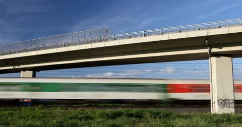 Fast train going really fast through a lovely summer landscape a Stock Photos