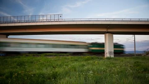 Fast train going swiftly through summer landscape and passing un Stock-Fotos