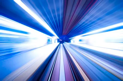 Fast train passing by train station at dusk. Stock Photos
