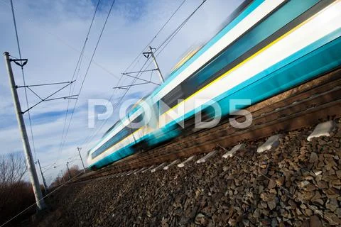 Fast train passing under a bridge on a lovely summer day (motion Stock Photos