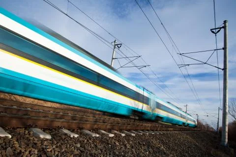 Fast train passing under a bridge on a lovely summer day (motion Fotos de archivo