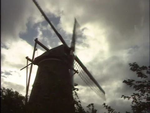 Fast turning windmill in front of a dark threatening sky  - low angle Video stock 168302182