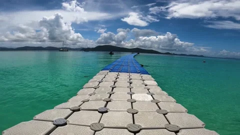 Fast walking on a hot floating pontoon off the coast of a tropical island Stock Footage 174941551
