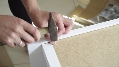 Fasten the back wall of a cabinet with small nails Stock Footage 94180279