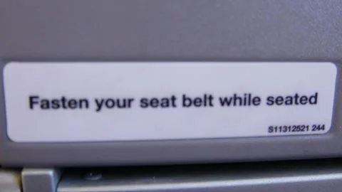 Fasten your seatbelt while seated, written on an airplane seat Stock Footage 281224757