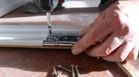 Fastening the hinge to the door frame Stock Photos