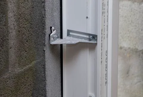Fastening a plastic window to the wall in level Stock Photos