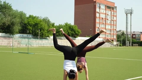 Faster, higher is written on the stadium in the background. Two young ladies are Stock Footage 311663568