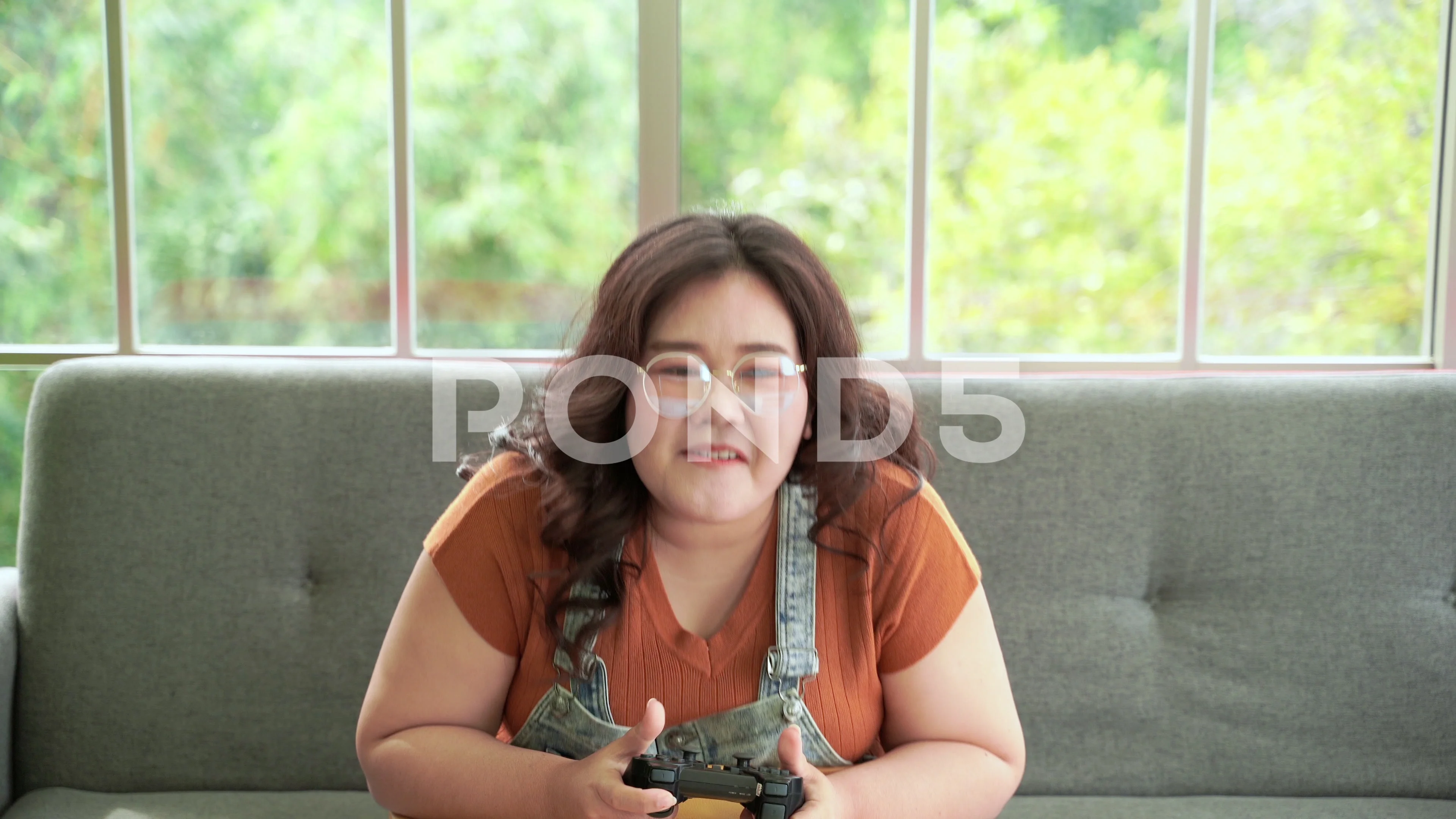 Fat Asian woman playing games with joyst... | Stock Video | Pond5