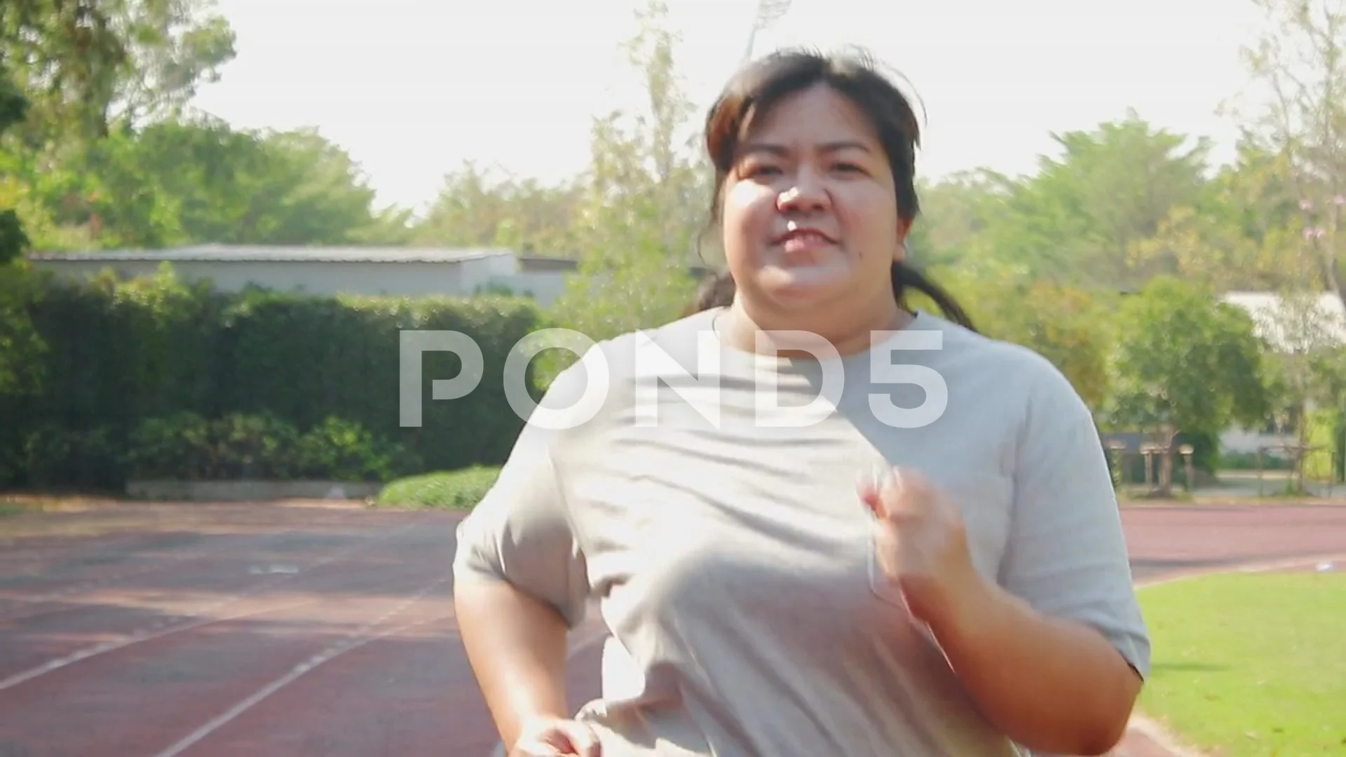 Fat Asian women jogging to lose weight in the morning.