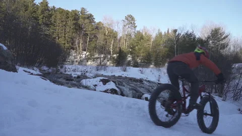 A fat biker riding by a river Stock Footage 144786338