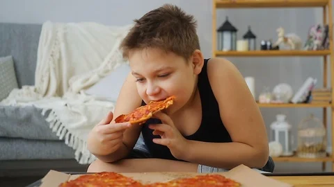 Fat boy eating pizza Stock Footage 100147141