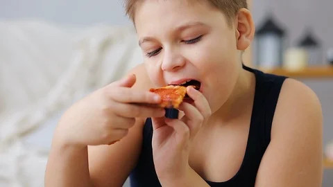 Fat boy eating pizza Stock Footage 100148157