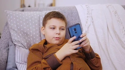 Fat boy playing on smartphone Stock Footage 99938311