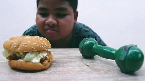 The fat boy's choice between burger that make you fat or dumbbell made thin Stock Footage 107001707