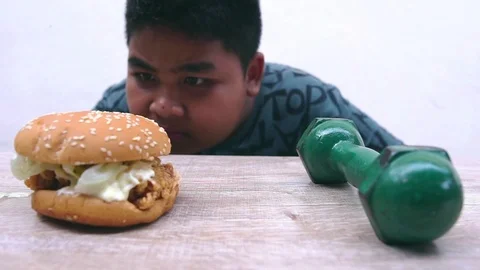 The fat boy's choice between burger that make you fat or dumbbell made thin Stock Footage 107001795