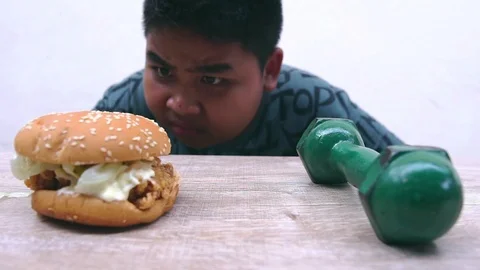 The fat boy's choice between burger that make you fat or dumbbell made thin Stock-Footage 107001808