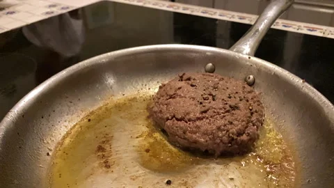 Fat Burger cooks in thick layer of oil and grease on stove-top skillet or pan. Stock Footage 144849836