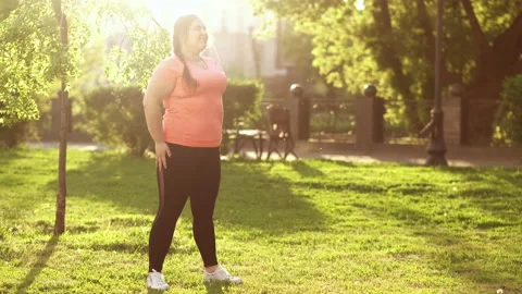 Fat burn exercising crouches outdoors summer park Stock Footage