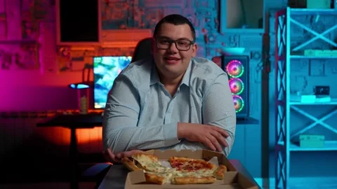 The Fat gamer plays at the computer and eats a burger and pizza. A Thick program Stock Footage 220419967