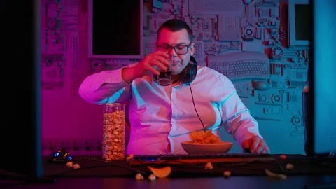 The Fat gamer plays at the computer and eats a burger and pizza. A Thick program Stock-Footage 220420632